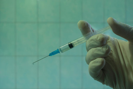 Syringe with an injection in the hand in a medical glove in the hospital