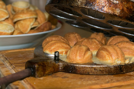 baked cookies in the form of nuts in the old aluminum form, on a wooden boardの写真素材