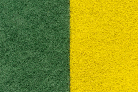 background of two colored green and yellow non-woven fibrous abrasive material, divided verticallyの写真素材