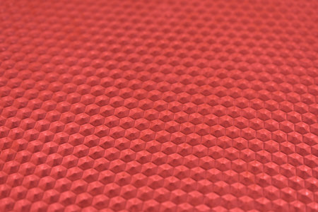 Plastic glass with a mosaic texture in the form of convex hexagons of red color