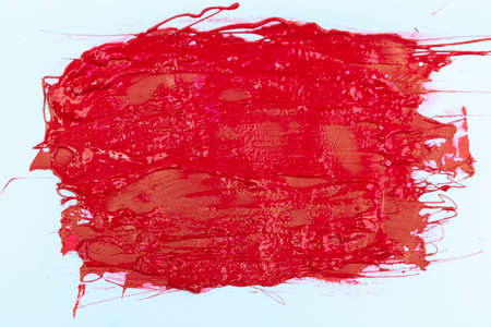 textured red color, smeared on a wall on a white backgroundの写真素材
