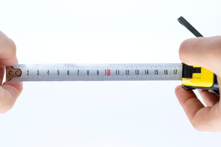 metal measuring tape in hand on white background