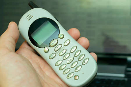 old vintage push-button cordless phone in hand, closeupの写真素材