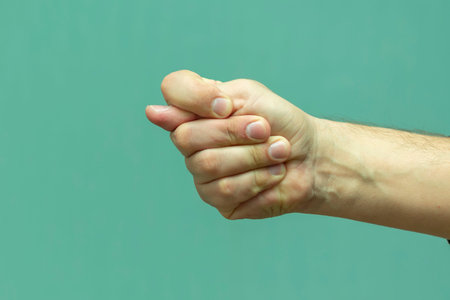 Male hand on white wall background, show a fig