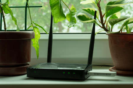 insert a mobile usb modem into the Internet router on the window sill by the windowの写真素材
