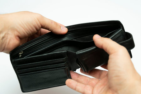 open empty black leather wallet in hands on a white background, closeup