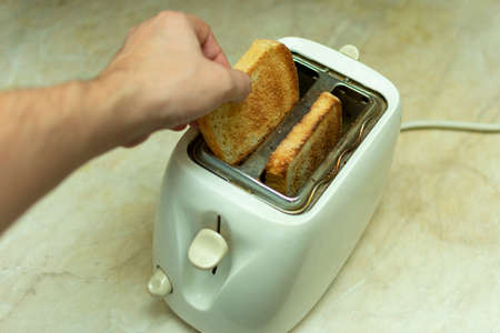 making breakfast toast bread with toaster at home kitchenの写真素材