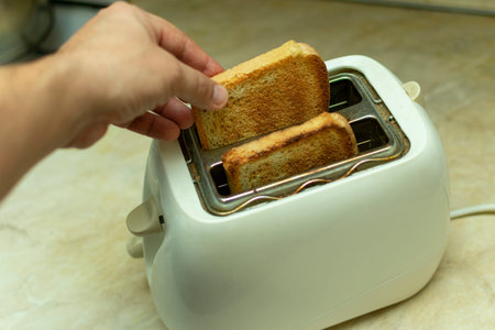 making breakfast toast bread with toaster at home kitchen