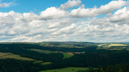 summer landscape, cloudy blue sky and green fields with forestsの写真素材