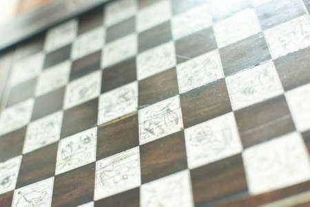 Chess board background. Handmade chessboard assembled from pieces of different woodの写真素材