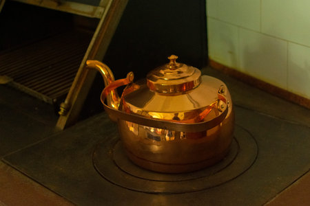 large antique copper teapot on the stove