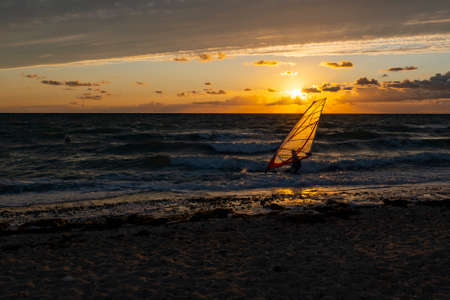 Sunset on the beach of the Baltic Sea with windsurferの写真素材
