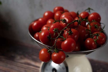 a bowl of cocktail tomatoes is weighedの写真素材