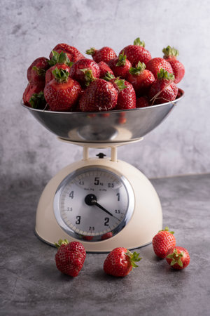 fresh, juicy strawberries are weighed in a scale panの写真素材