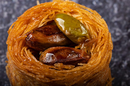 Macro shot of a duckhair beast with caramelized pistachios. Arranged on a black slate plate