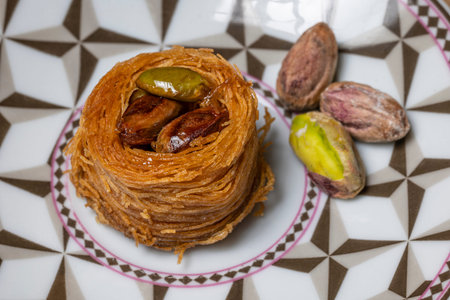 Close-up of an angel hair nest with caramelized pistachios. Arranged on a small plate and decorated...