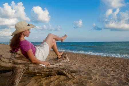 Woman on the sandy beach at sunsetの写真素材