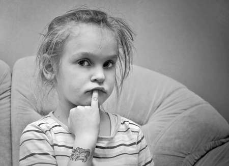 little thoughtful girl looking at the cameraの写真素材