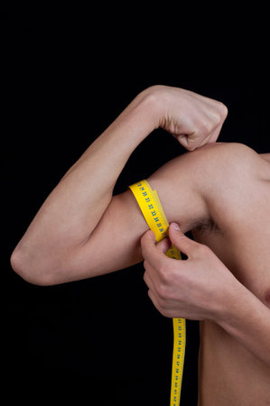 young man measuring his arm with centimeter