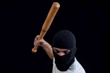 Hooligan with baseball bat ready for fight on blackの写真素材