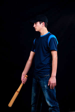young man playing baseball for fun on black backgroundの写真素材