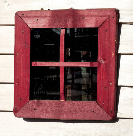 Red window of a old wooden houseの写真素材