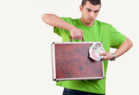 young man holding and showing a briefcase and money