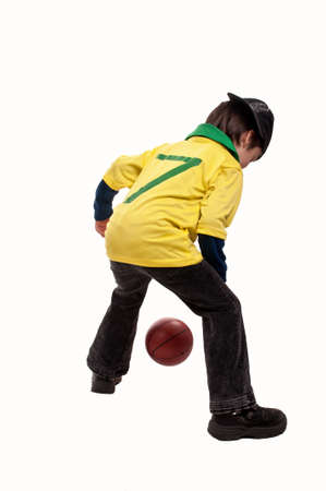 back of a young boy playing basketballの写真素材