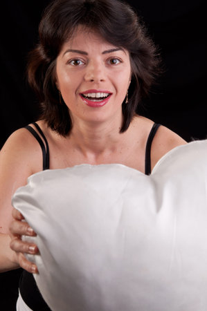 a beautiful young woman with a white heart in handの写真素材