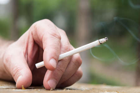 closeup of an cigarette in hand manの写真素材
