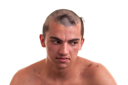 young man is disappointed that the barber by mistake wrong cut hair with clipper, funny conceptの写真素材