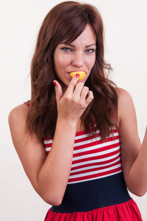 Close up young woman eating citrus fruitの写真素材