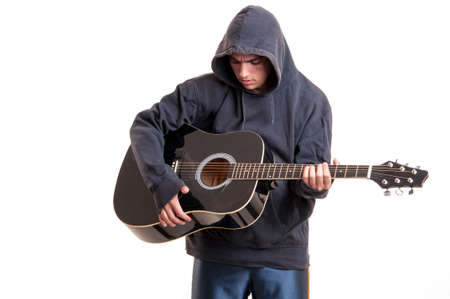 Teenager boy plays a acoustic guitar with much feelingの写真素材