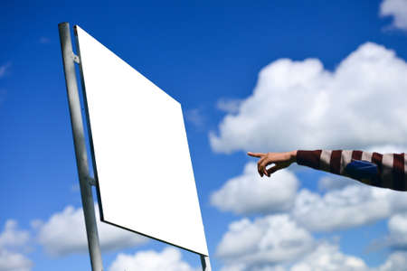young man holding his arm out presenting a blank board outsideの写真素材