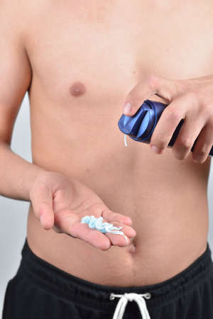 Young man with shaving foam on the palm preparing to shave, close upの写真素材