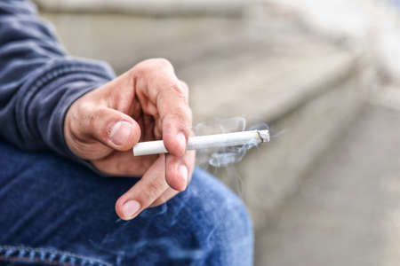 Young male hand holding a cigaretteの写真素材