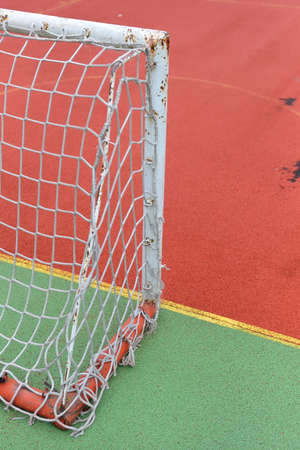 Detail of old and rusty gate of mini football at a soccer field made from red and green granule rubber.の写真素材