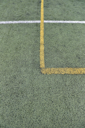 Detail of crossed yellow and white lines on football playground. Lines in a soccer field made from...