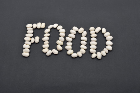 Word made from white beans on black background. Food vegan, vegetarian. Healthy food