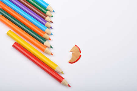 Close up of arranged colored pencils with pencil shavings on white background. Selective focusの写真素材