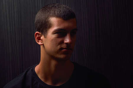 Portrait of thinking teenager looking to the side in a studio. Lights and shadowsの写真素材