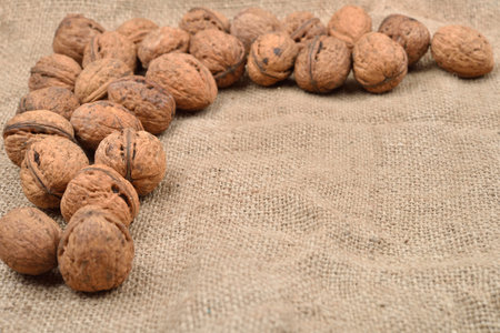 Natural, unbroken nuts on a jute bag background. Selective focus. Space for textの写真素材