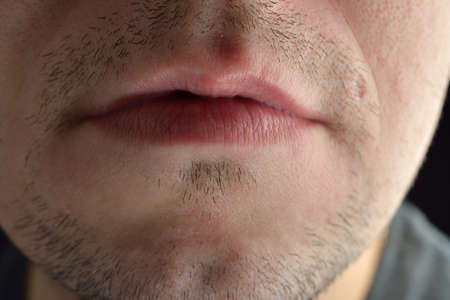 Lips, short beard of a young man. Concept photo of male sexuality and skin medical careの写真素材