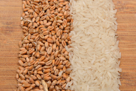 Lines of beans of dried rice and wheat lying on wood background. Rustic image. Concept of healthy...