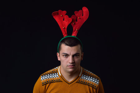 Young man wearing reindeer horns with funny expressions. Funny image great for christmas greeting...