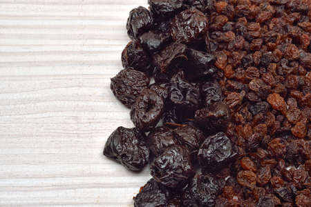 Raisin and plum fruits on white wooden background. Healthy bio food. Copy spaceの写真素材