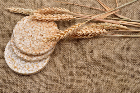 Product made from wheat, expanded and ears wheat on o jute background. Healthy organic food....