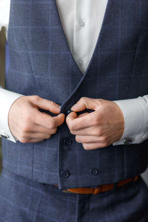 The groom wears cufflinks for shirtの写真素材