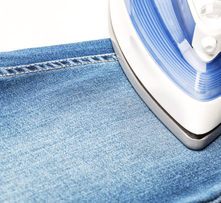 Ironing jeans on a white baclground