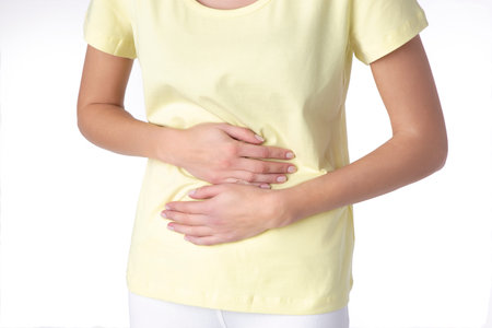 Young beautiful woman having painful stomachache on white background.Chronic gastritis. Abdomen...